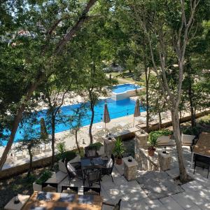 an outdoor patio with tables and chairs and a pool at Green Hill Apartments in Ulcinj
