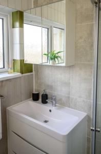 uma casa de banho com um lavatório branco e um espelho. em Frodo's Folly by StayStaycations em Port Talbot