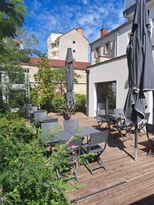 un mucchio di ombrelloni e sedie su una terrazza di legno di Hôtel des Halles a Digione