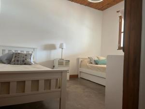 a white bedroom with a bed and a window at La Puerta Azul San Carlos in San Carlos