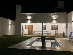 una casa con piscina en el patio por la noche en La Puerta Azul San Carlos en San Carlos