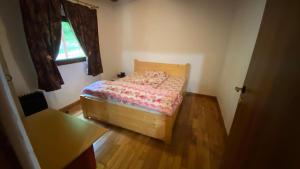 a small bedroom with a bed and a window at Casuta din poiana Rau Sadului in Rau Sadului