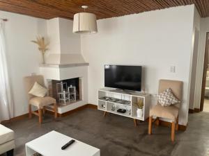 a living room with a flat screen tv and chairs at La Puerta Azul San Carlos in San Carlos