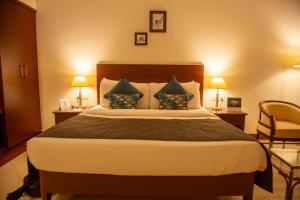 a bedroom with a bed with two lamps and a chair at Naveen Residency in Amargol