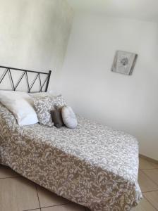 een bed met witte lakens en kussens erop bij L'Eden in Les tres Cales