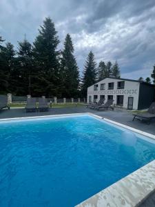 a large blue swimming pool in front of a house at Феєрія Лісу in Skhidnitsa