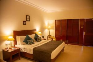 a hotel room with a large bed and a table at Naveen Residency in Amargol