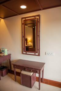 a mirror and a bench in a room with a mirror at Naveen Residency in Amargol