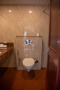 a bathroom with a white toilet and a sink at Naveen Residency in Amargol