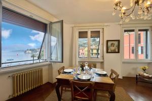 uma sala de jantar com uma mesa e uma grande janela em Casa Valentina em Menaggio