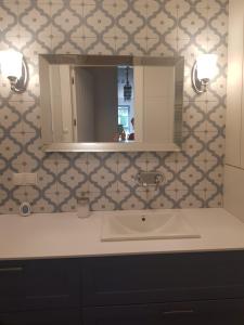 een badkamer met een wastafel en een spiegel bij Wave Apartments - SILVER NADMORZE in Gdańsk