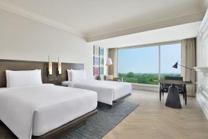 a hotel room with two beds and a piano at Le Meridien Amritsar in Amritsar +77 photos