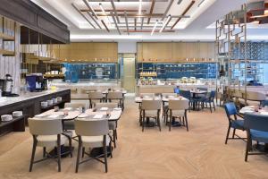 a restaurant with tables and chairs and a bar at Le Meridien Amritsar in Amritsar