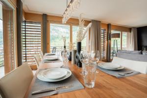 a dining room with a table with plates and glasses at Fantastic panoramic view home in Zermatt in Zermatt