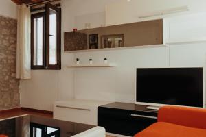 a living room with a flat screen tv and a couch at La Dolce Vita Cittadella in Pitigliano