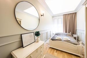 - une chambre avec un lit et un miroir dans l'établissement Apartamenty Poznańska 15, à Inowrocław