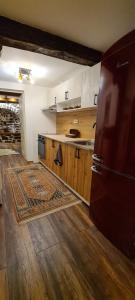 uma cozinha com um frigorífico, armários de madeira e um tapete em Lazarov Suites - country style luxury appartements em Veliko Tarnovo
