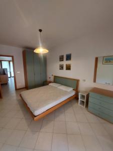 a bedroom with a large bed and a dresser at Corallo Cavallino in Cavallino-Treporti