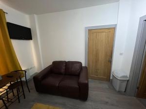 a living room with a brown couch and a door at Ground Floor Two Bed Cairo Street in Warrington