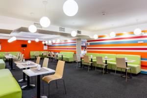 a restaurant with colorful walls and tables and chairs at PracticOtel in Kyiv