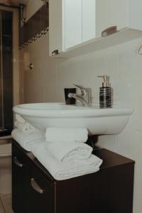 a bathroom with a sink and towels on a vanity at La Dolce Vita Cittadella in Pitigliano