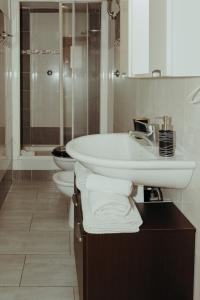 bagno bianco con 2 servizi igienici e lavandino di La Dolce Vita Cittadella a Pitigliano