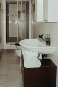 a white bathroom with two toilets and a sink at La Dolce Vita Cittadella in Pitigliano +29 photos