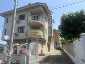 un edificio de apartamentos con una valla delante en Guest House Karavida en Sinemorets