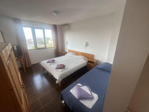 1 dormitorio con 2 camas y ventana en Guest House Karavida en Sinemorets
