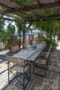 a table and chairs sitting under a pergola at Archontiko Repana - Makrinitsa Stone Retreat in Makrinítsa