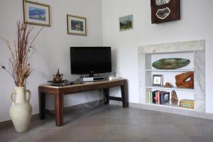 a room with a desk with a television and a fireplace at Agriturismo Villa Cheti in Spigno Monferrato