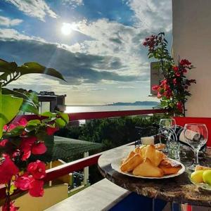 einen Tisch mit einem Teller Essen auf dem Balkon in der Unterkunft ADRIATIC Seaview Apartments in Durrës
