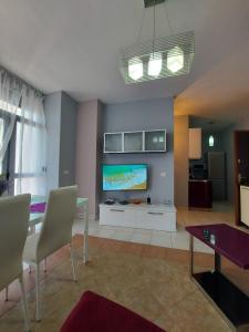 ein Wohnzimmer mit einem TV und einem Tisch in der Unterkunft ADRIATIC Seaview Apartments in Durrës