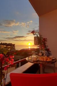 einen Tisch auf dem Balkon mit Blick auf den Sonnenuntergang in der Unterkunft ADRIATIC Seaview Apartments in Durrës