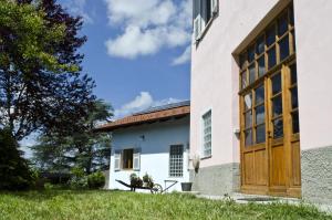 a house with a large wooden door on the side of it at Agriturismo Villa Cheti in Spigno Monferrato