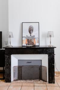 a fireplace with a picture on top of it at Maison Madeleine in La Flèche