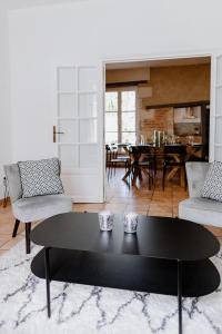 a living room with a black coffee table and a dining room at Maison Madeleine in La Flèche
