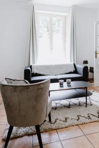 a living room with a couch and a table and a chair at Maison Madeleine in La Flèche