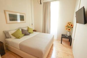 een wit bed in een kamer met een raam bij MONAHOUR in Heraklion