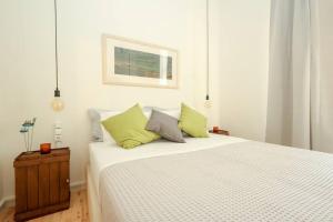 een slaapkamer met een groot bed met groene kussens bij MONAHOUR in Heraklion