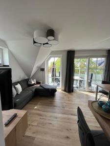 uma sala de estar com um sofá e uma mesa em Winkelschiffchen III mit Sauna em Juist