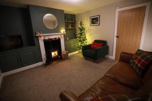 a living room with a christmas tree and a couch at Auctioneers Cottage in Louth