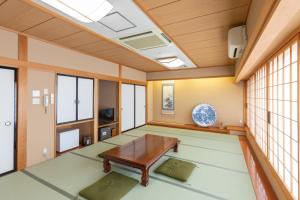 um quarto vazio com uma mesa e janelas em 天然温泉白川郷の湯 em Shirakawa