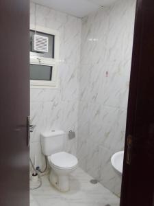 biała łazienka z toaletą i umywalką w obiekcie الخورى تاور w Szardży