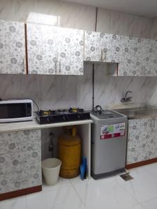 a kitchen with a sink and a stove and a microwave at الخورى تاور in Sharjah