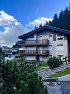 a building with a balcony and stairs in front of it at Monolocale in centro a Campiglio, ad 80mt dagli impianti in Madonna di Campiglio