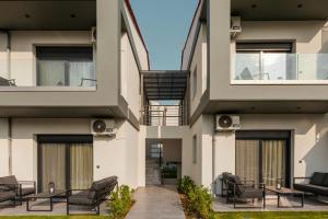an apartment building with two balconies and chairs at Villa Irene in Polychrono