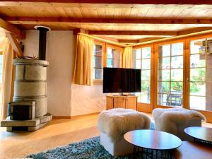 a living room with a fireplace and a flat screen tv at Rafaches in Grimentz