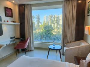 a hotel room with a bed and a window at Udman Hotel Chhattarpur in New Delhi