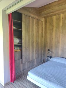 um quarto com uma cama com uma cortina vermelha em Camera Aminta - Casa Aminta em Valtesse